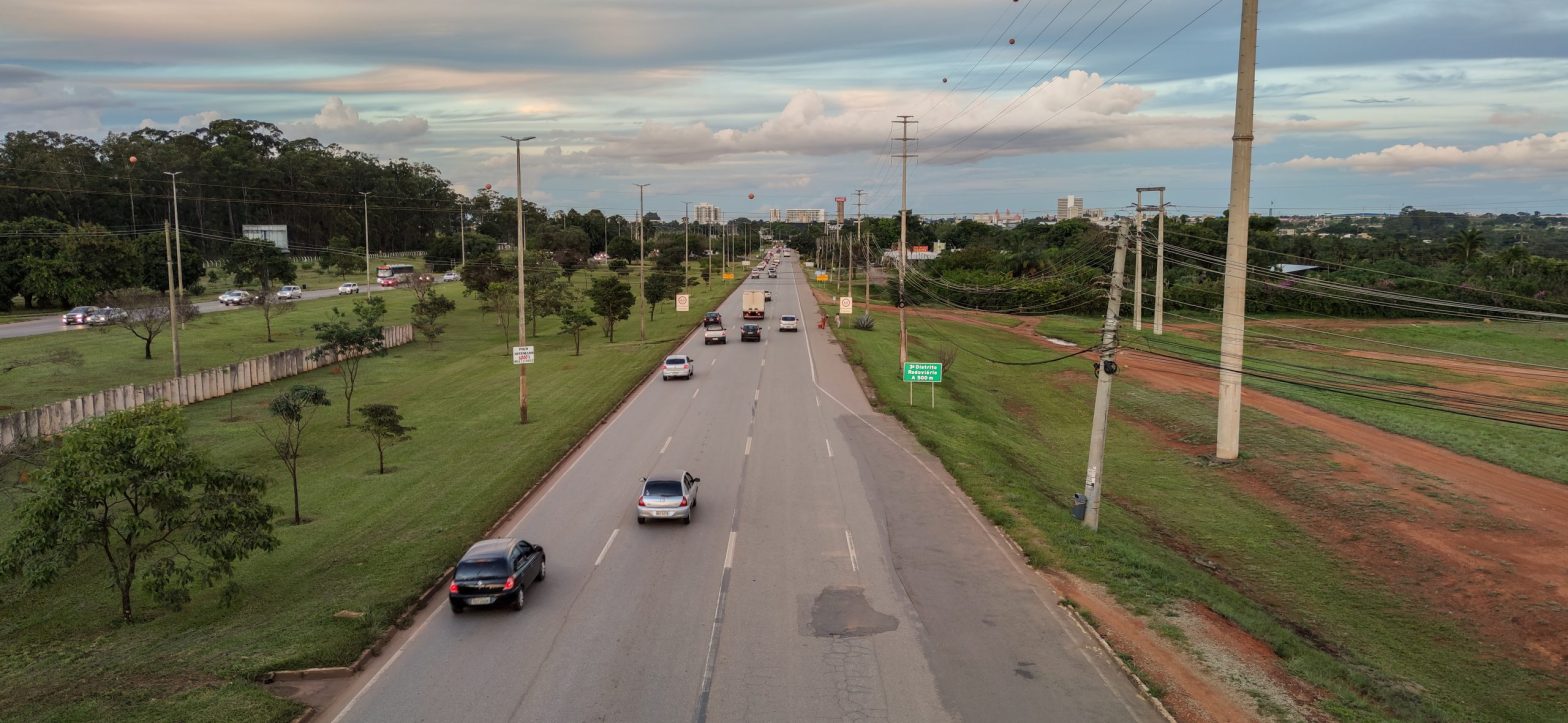 Rodovia em Goiás com tráfego fluindo livremente, carros em circulação e cenário urbano ao fundo, representando o sistema Free Flow e o pagamento automático de pedágio com ConectCar.